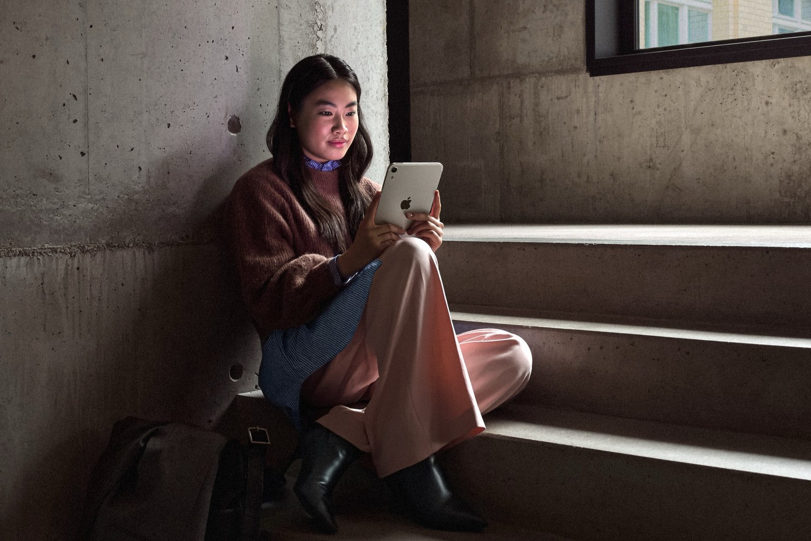 用戶坐在樓梯上使用 iPad mini